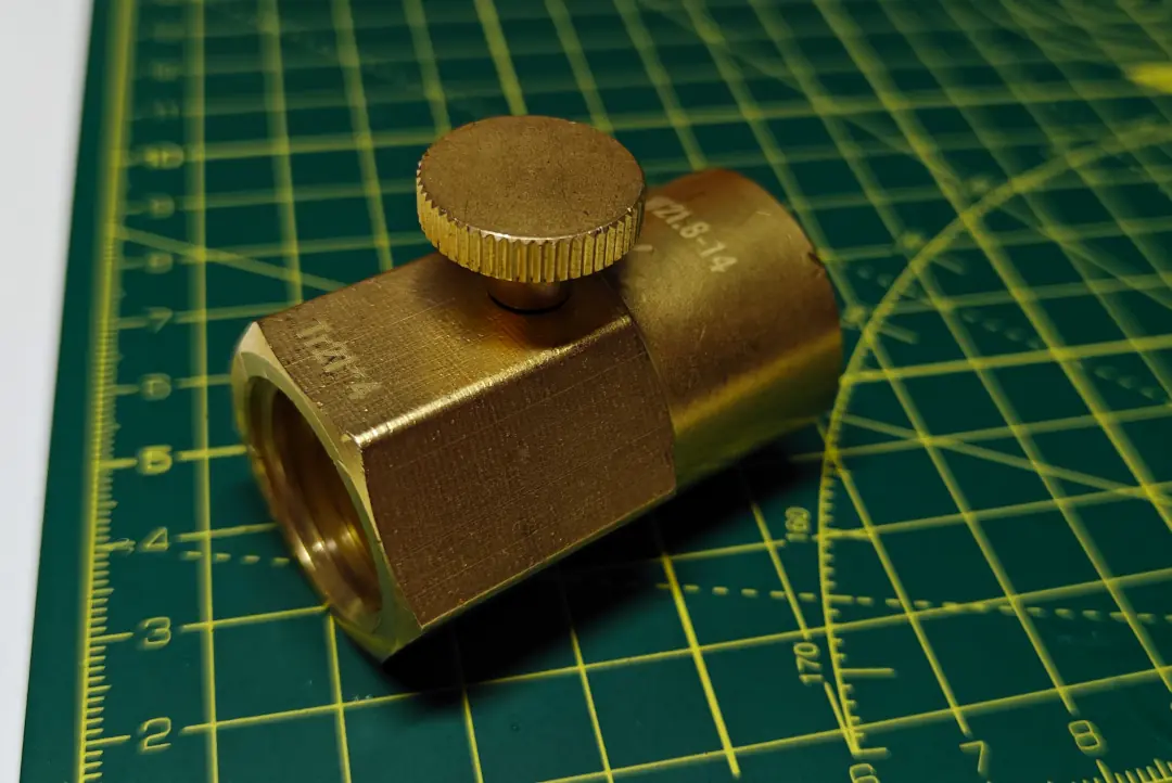 A bronze coloured straight fitting, with a little thumbscrew in the middle